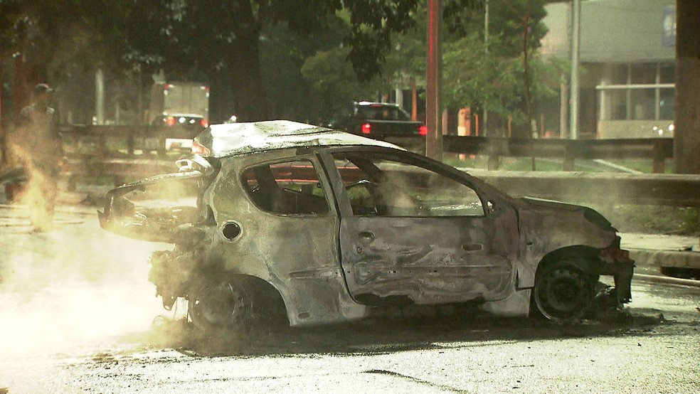 Veículo da vítima ficou irreconhecível após ser consumido pelo fogo (Foto: Reprodução/TVGlobo)