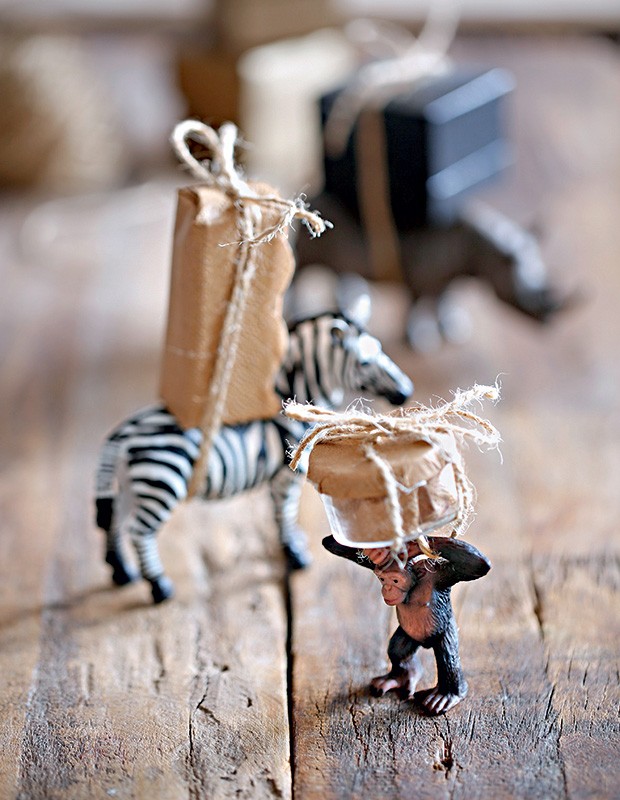 Bichinhos miniaturas carregando caixas embrulhadas em papel pardo