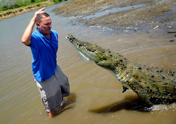 Hmem chocou turistas ao fazer carinho e interagir com um crocodilo enorme às margens do Rio Grande (Foto: Ezequiel Becerra/AFP)