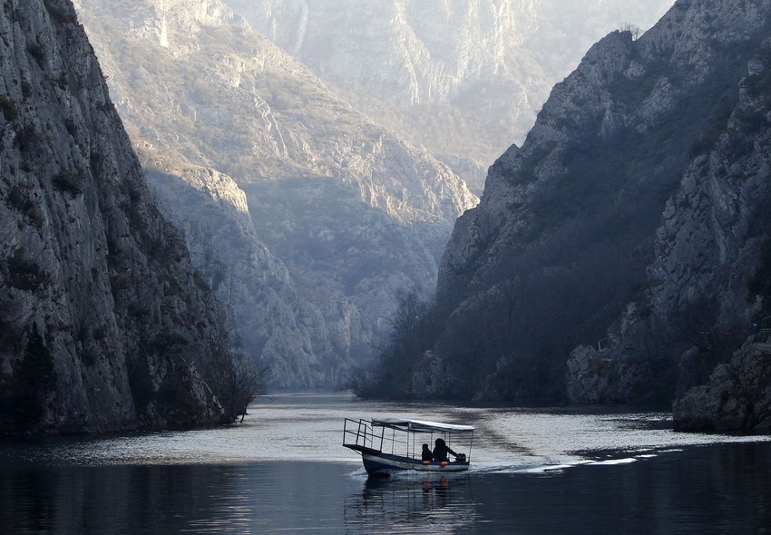 Barco navega nas águas do rio Treska, no canion Matka, na Macedônia. Rio apresenta volume máximo com o fim do período de chuvas fortes na região