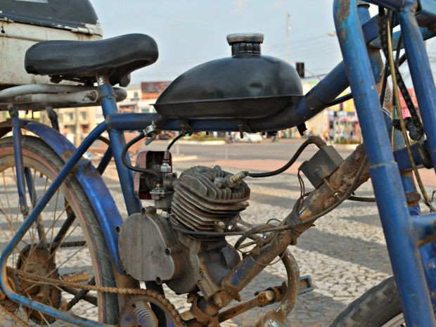 Bicicleta é adaptada com um motor, originalmente, de roçadeira (Foto: Caio Fulgêncio/G1)