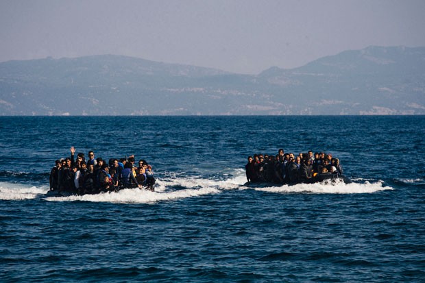 Migrantes chegam de barco na ilha grega de Lesbos após atravessarem o mar desde a Turquia nesta sexta-feira (9) (Foto: Dimitar Dilkoff/AFP)