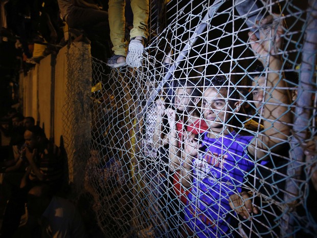 Palestinos esperam na fronteira entre Israel e o norte da Faixa de Gaza, a chegada de prisioneiros palestinos libertos nesta terça (13) (Foto: Suhaib Salem/Reuters)