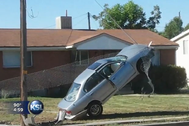 Motorista ficou com o carro pendurado após atingir um cabo. (Foto: Reprodução)