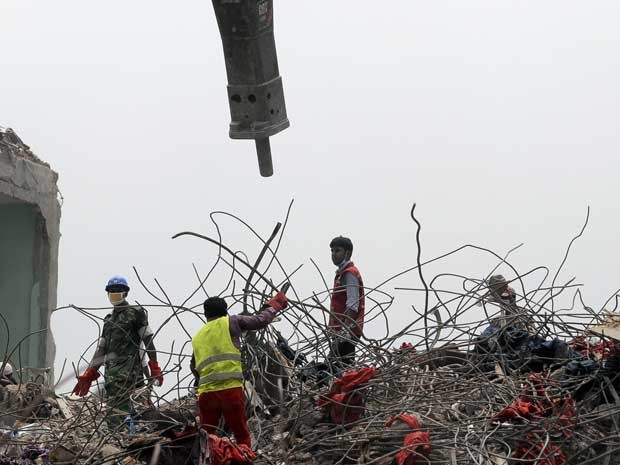 Equipes de resgate seguem à procura de corpos entre os escombros de prédio que desabou em Bangladesh. (Foto: Ismail Ferdous / AP Photo)