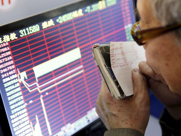 Investidor de Shangai observa comportamento dos índices após novo circuit breaker nesta quinta-feira  (Foto: Reuters)