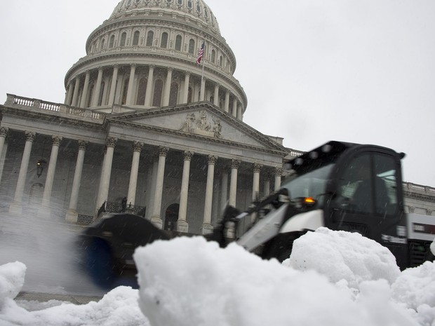 Escavadeira retira neve acumulada do lado de fora do edifício do Capitólio dos EUA em Washington. (Foto: Jim Watson/AFP)