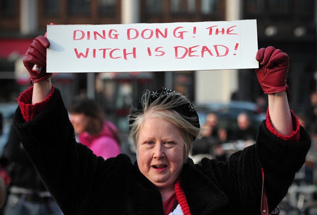 Com cartaz 'a bruxa está morta', mulher comemora a morte de Margaret Thatcher nesta segunda-feira (8) em Londres (Foto: AFP)