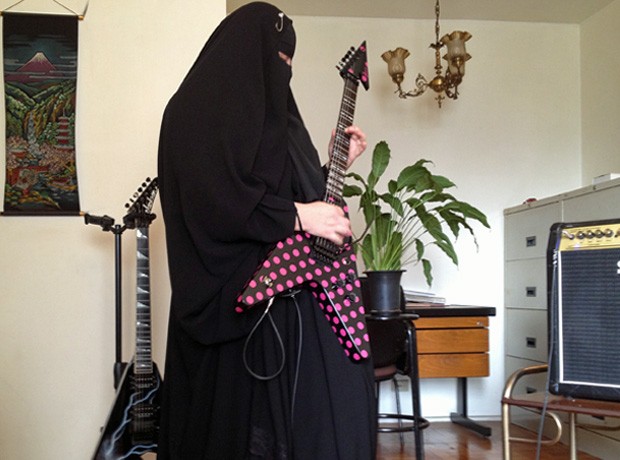 Gisele Marie em sua casa, ensaiando em sua guitarra customizada (Foto: Giovana Sanchez/G1)