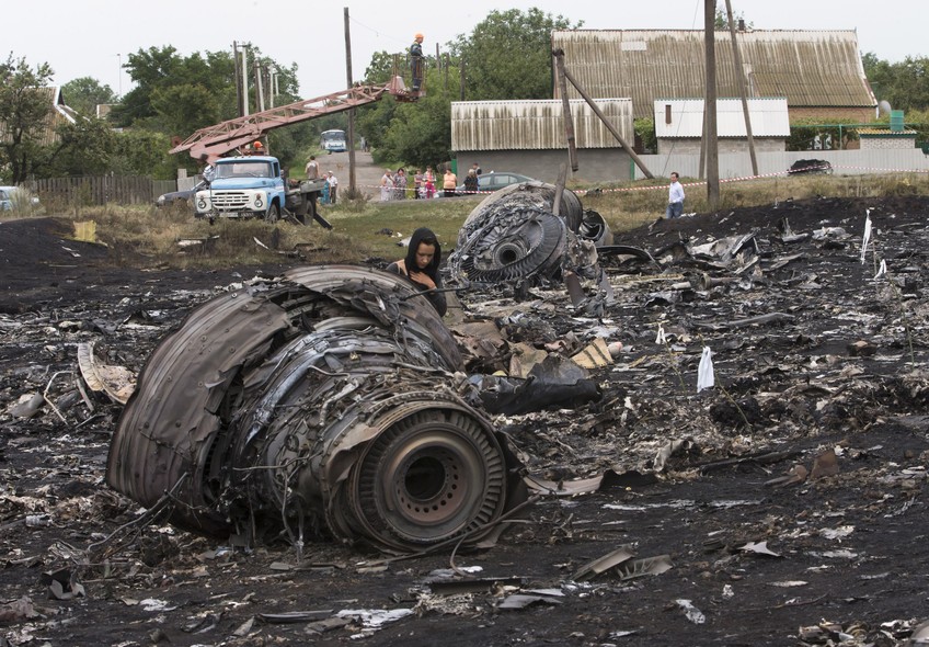 Moradora do vilarejo de Rozsypne, no leste da Ucrânia, observa os destroços do Boeing 777 que caiu na quinta-feira (17), com pelo menos 295 pessoas a bordo