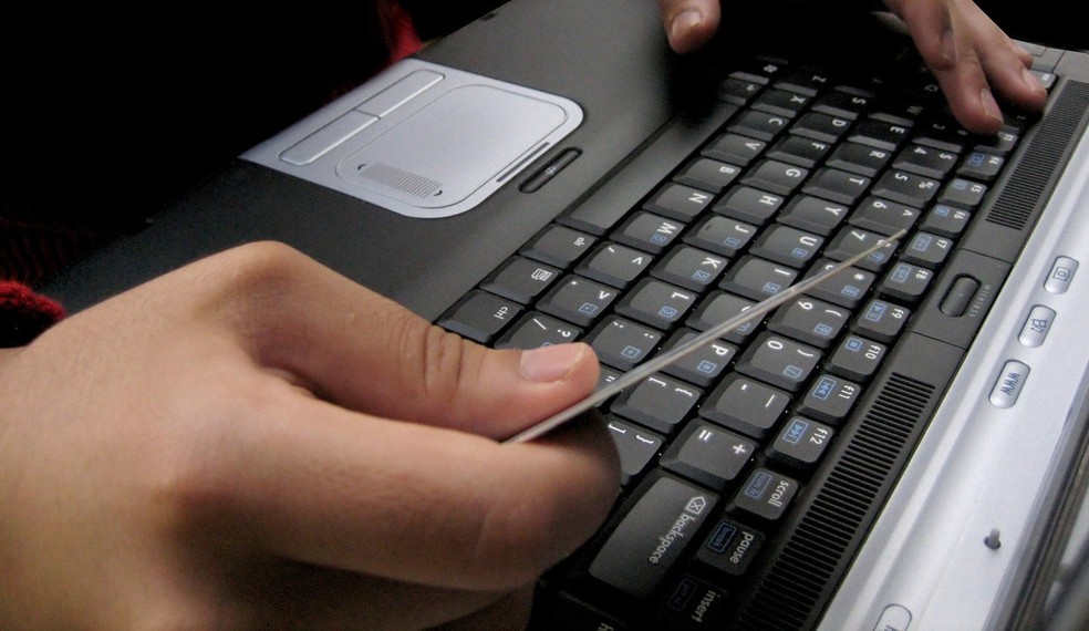 Contribuinte usa cartão enquanto digita em notebook (Foto: Divulgação)