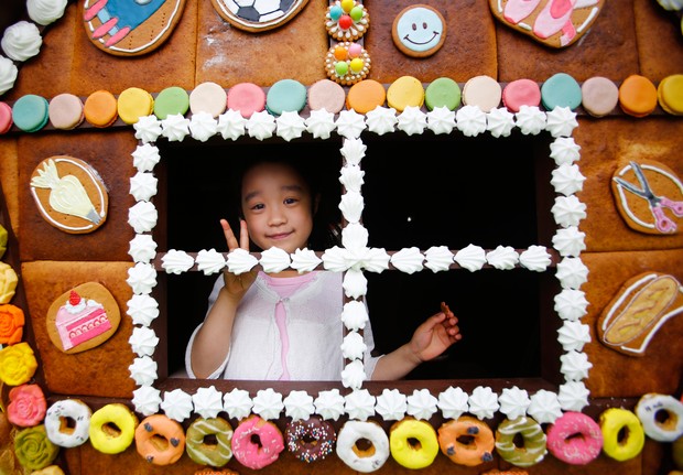 Nanami Miyazaki, de seis anos, brinca no interior da casinha feita de doces (Foto: Shizuo Kambayashi/AP)