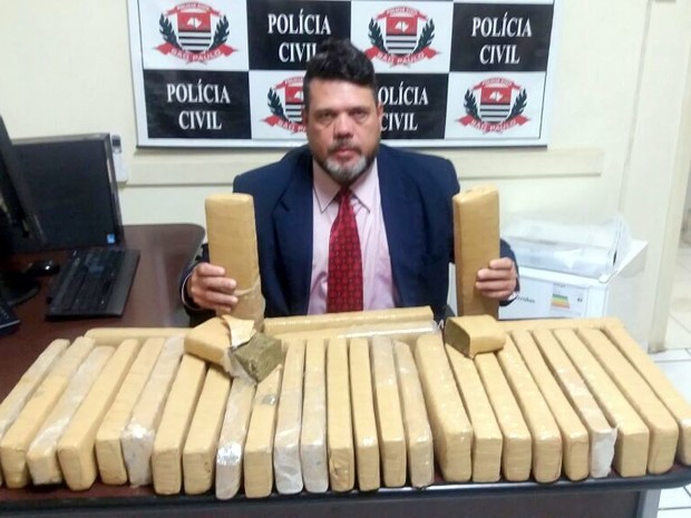 Delegado Gillys Scrocca com 32 'tijolos' de maconha apreendidos pela PM (Foto: Divulgação/Polícia Civil)