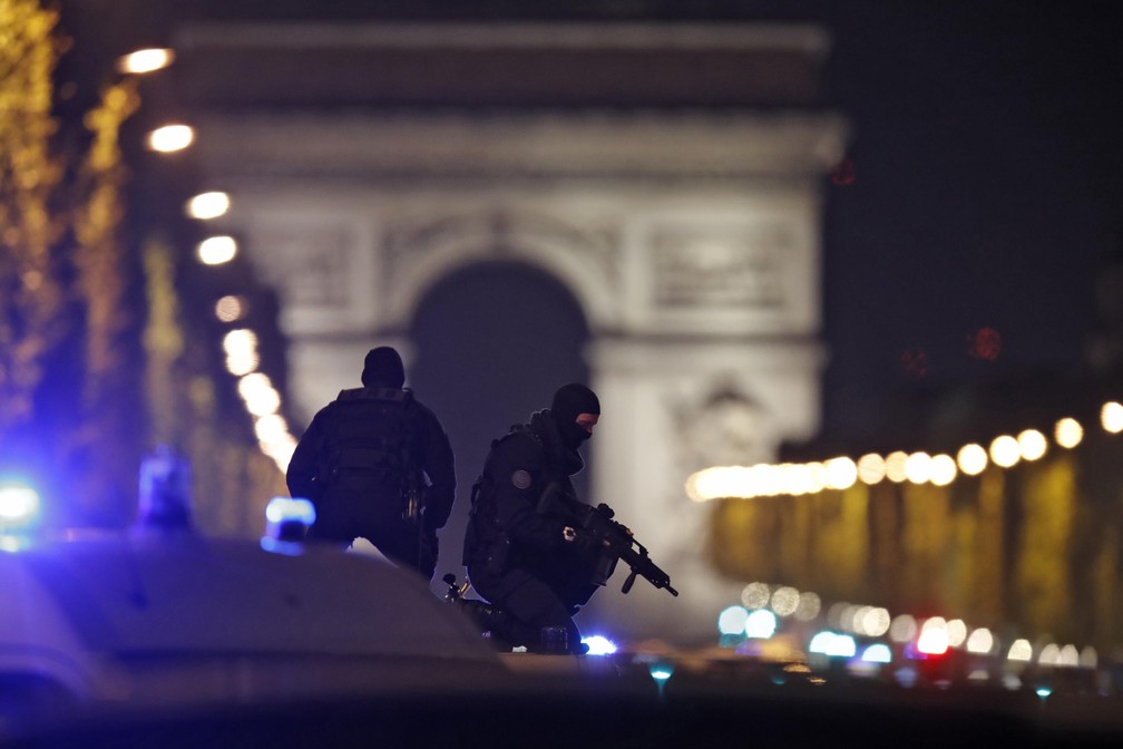 Policiais mascarados vigiam avenida Champs-Élysées de cima de um veículo (Foto: REUTERS/Christian Hartmann ) Policiais mascarados vigiam avenida Champs-Élysées de cima de um veículo (Foto: REUTERS/Christian Hartmann )