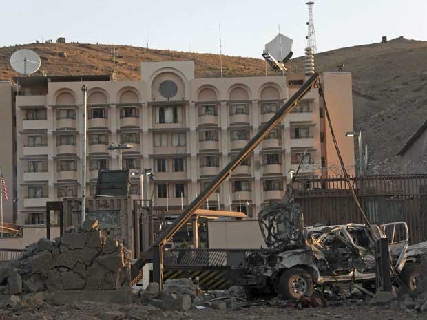 Veículo danificado após explosão no portão de entrada do consulado dos EUA no Afeganistão. Ao fundo, o prédio diplomático. (Foto: Hoshang Hashimi / AP Photo)