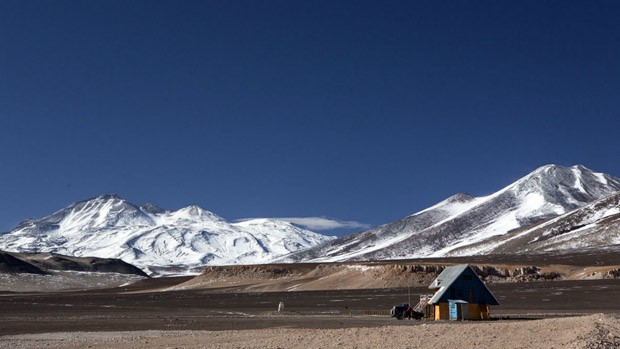 3.	Este é o refúgio Murray, onde a equipe esperou o tempo na região melhorar. Muito dos picos com mais de 5.000 m nunca escalados dos Andes ficam vizinhos ao vulcão Ojos Del Salado, 6.893 m, visto nesta imagem (Foto: Caio Vilela)