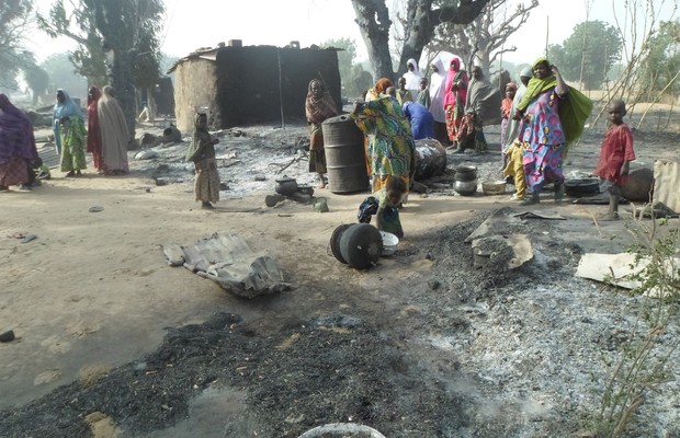 Mulheres e crianças olham para o que restou das casas na vila de Dalori, no nordeste da Nigéria, depois de um ataque do Boko Haram no dia 31 de janeiro. (Foto: AP)