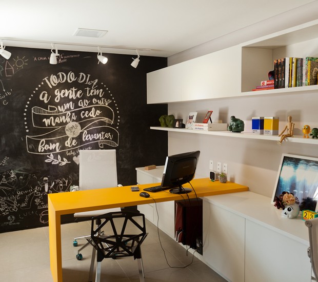 Escritório | O ambiente mais divertido do lar é o escritório. A mesa de nanoglass amarela da Carioca Granitos dá um toque especial ao cômodo, junto com a parede de lousa. Prateleiras planejadas pela Stanza Móveis (Foto: Maurício Pokemon/Divulgação )