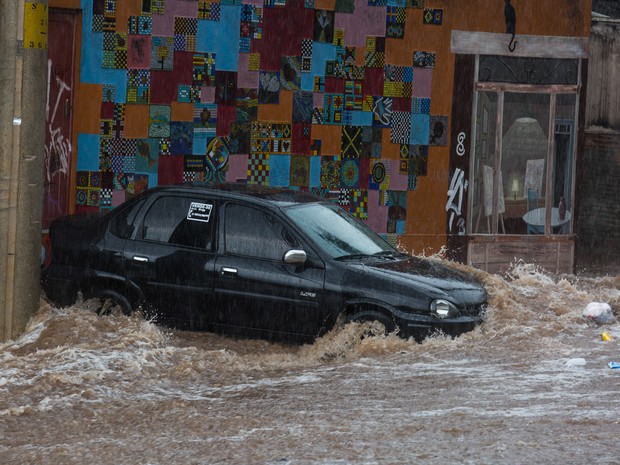 Um carro é arrastado em direção à calçada durante chuva na Vila Madalena, em São Paulo (Foto: Victor Moriyama/G1)