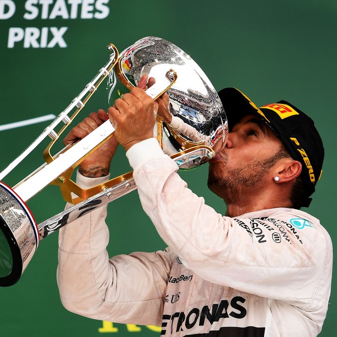 Lewis Hamilton bebe champanhe no troféu para celebrar vitória no GP dos EUA e título mundial  (Foto: AFP)