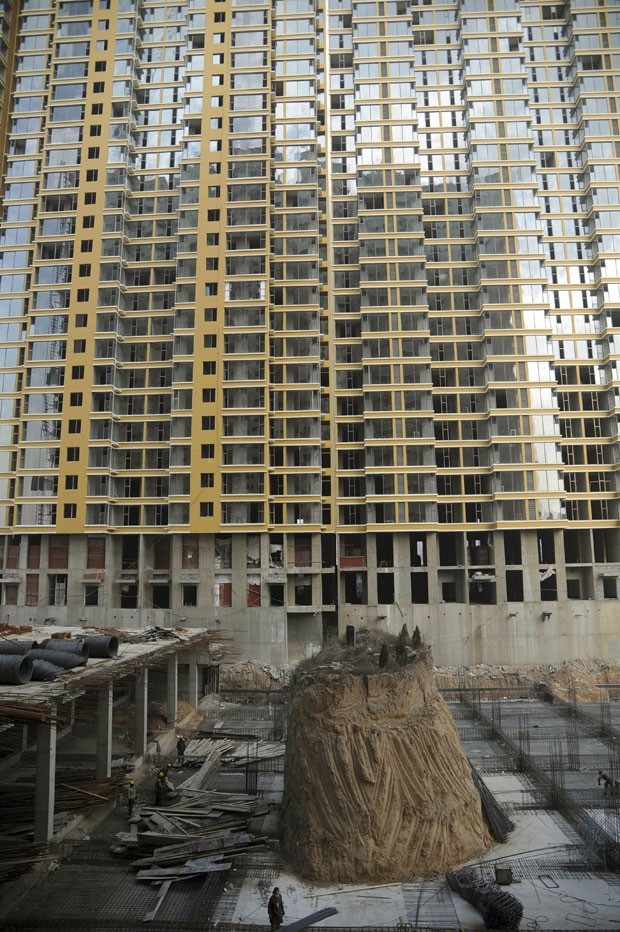 Em 2012, após falta de acordo, um prédio teve sua construção iniciada ao redor de um túmulo em Taiyuan, na província de Shanxi, na China. Só depois de meses de negociação, o túmulo acabou transferido para outro local (Foto: AP)