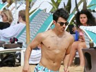 Sem camisa, Joe Jonas curte praia com a namorada no Havaí