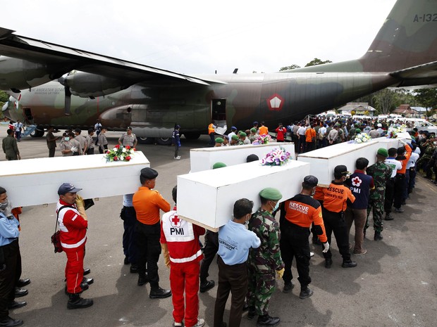 Caixões com os restos mortais dos passageiros do voo da AirAsia são transportados para Surabaya neste sábado (3) (Foto: Darren Whiteside/Reuters)