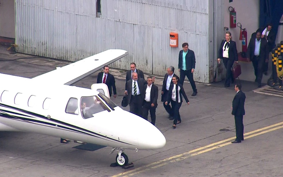 O ex-presidente Luiz Inácio Lula da Silva entra no avião que vai levá-lo a Curitiba (Foto: TV Globo/Reprodução)