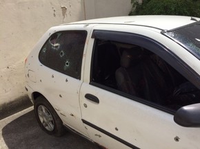 Carro dos rapazes ficou com diversas marcas de tiro. (Foto: Janaína Carvalho / G1)
