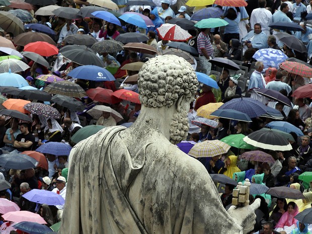 Sob chuva, fieis se aglomeram na Praça São Pedro, no Vaticano, para assistir à missa deste domingo (5) celebrada pelo Papa Francisco (Foto: Andreas Solaro/AFP)