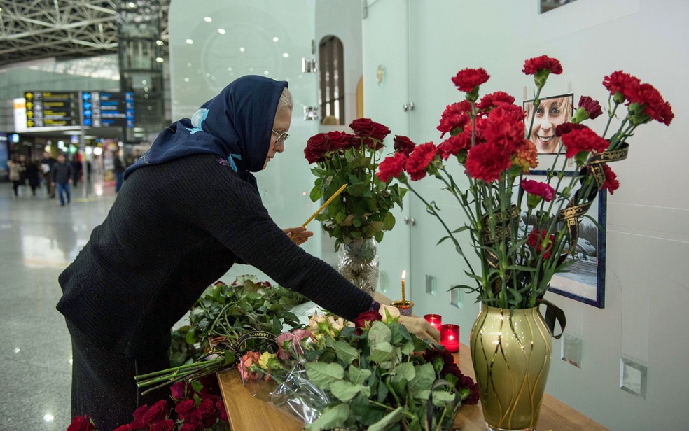 Pessoas deixam flores no aeroporto de Sochi um dia depois da queda do avião militar russo (Foto: Yekaterina Lyzlova/AFP)