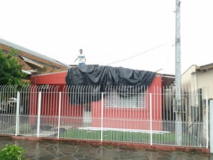 Homem cobre residncia com lona em Esteio, uma das cidades mais afetadas pelo temporal no RS (Foto: Vanessa Felippe/RBS TV)