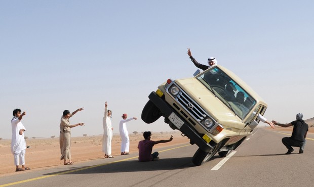 Carro é visto trafegando com passageiros em apenas duas das quatro rodas (Foto: Mohamed Al Hwait/Reuters)