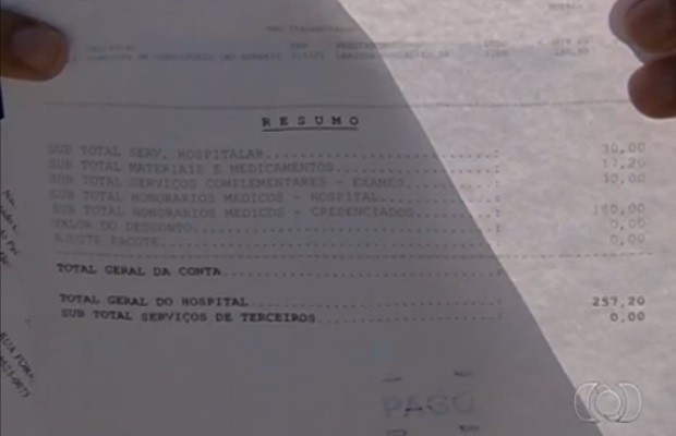 Vendedor mostra recibo das despesas hospitalares, em Goiânia, Goiás (Foto: Reprodução/ TV Anhanguera)
