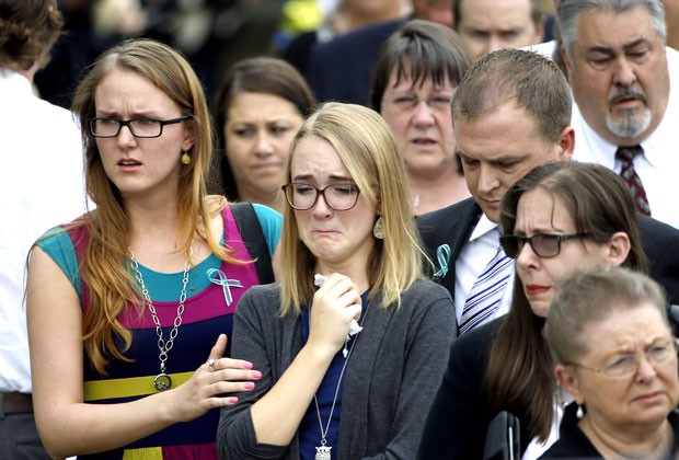 Cassidy Stay (ao centro) chora durante o velório de seus pais e irmãos em Houston, nos EUA, nesta quarta-feira (16) (Foto: David J. Phillip/AP)
