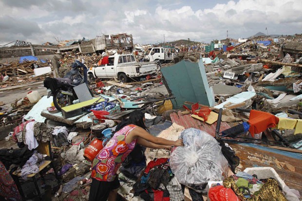 Mulher procura mantimentos e roupas em casa destruída por tufão em Tacloban (Foto: Romeo Ranoco/Reuters)