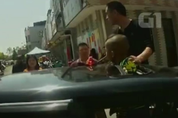 Bombeiros ajudaram menino que ficou preso em teto solar de carro na China (Foto: CCTV)