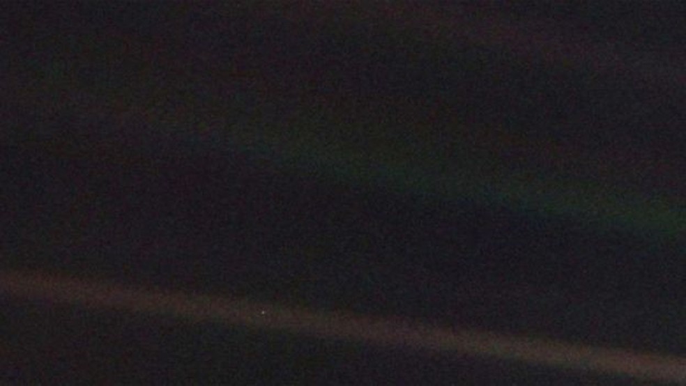 Uma foto escura, em que não se vê nada? Olhe novamente com atenção. O minúsculo pontinho claro é a Terra, a seis bilhões de quilômetros, onde estava a sonda Voyager em 1990. A faixa mais clara sobre o fundo escuro é um raio de luz dispersada. (Foto: Nasa)