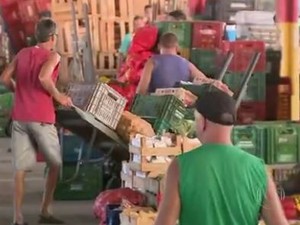 Feirante (de vermelho) foi flagrado comprando produtos no Ceasa e vendendo como orgânicos (Foto: Reprodução/RBS TV)
