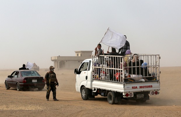 Civis passam por Tob Zawa, a 9 km de Mossul, durante ofensiva expulsar o EI (Foto: Khalid Mohammed/AP)