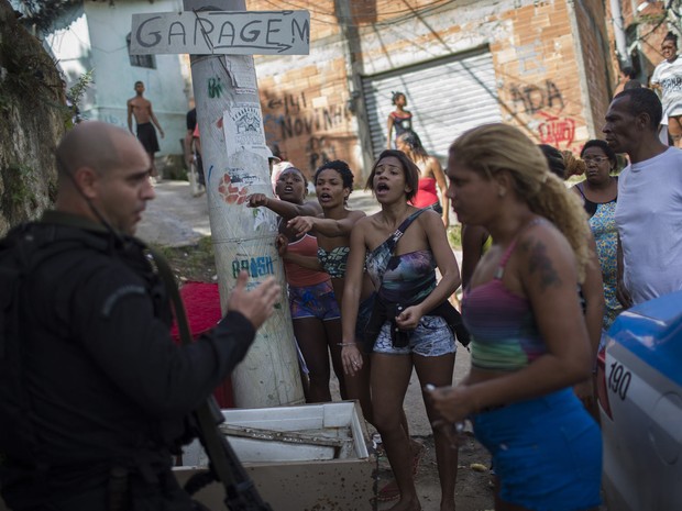 Moradores gritam com policiais do Bope após a descoberta de dois corpos no mato no morro de São Carlos, no Rio de Janeiro (Foto: Felipe Dana/AP) Moradores gritam com policiais do Bope após a descoberta de dois corpos no mato no morro de São Carlos, no Rio de Janeiro (Foto: Felipe Dana/AP)