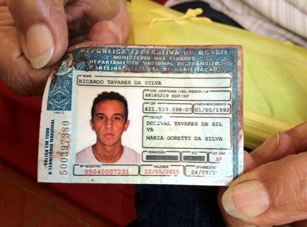 Dorival Tavares da Silva mostra a carteira de motorista do filho manchada de sangue (Foto: Giovana Sanchez/G1)