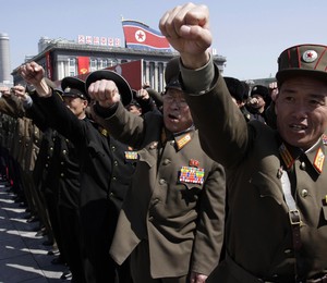 Oficiais do exército da Coreia do Norte dão socos no ar durante um comício na praça Kim Il Sung, no centro de Pyongyang. Dezenas de milhares de cidadãos compareceram ao local  (Foto: AP Photo/Jon Chol Jin)