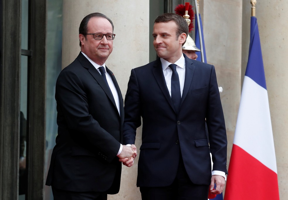 Macron e Hollande se cumprimentam na chegada do novo presidente ao Palácio do Eliseu para a cerimônia de posse neste domingo (14) (Foto: Benoit Tessier/Reuters)