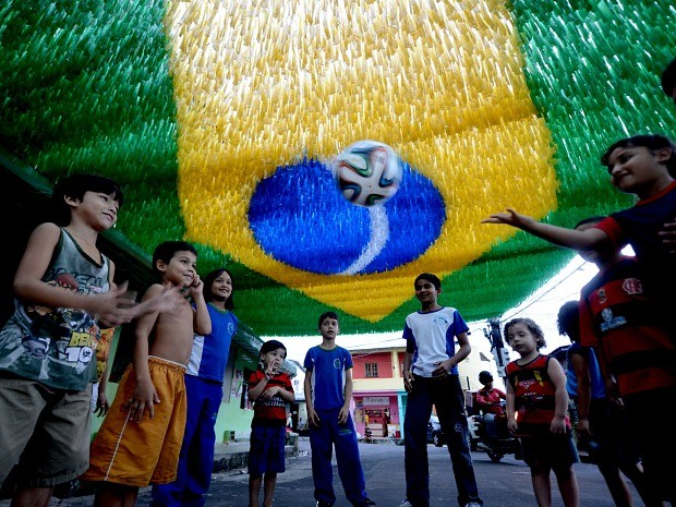 Crianças brincam com a bola da Copa, 'Brazuca', em rua de Manaus (Foto: Chico Batata/Agecom)