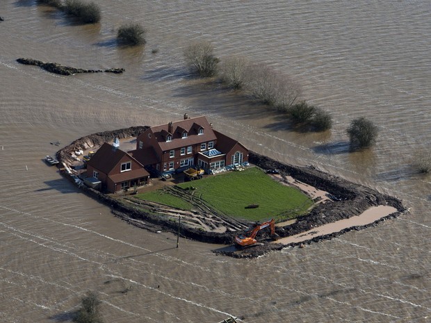 O proprietário de uma das residências afetadas pelas enchentes no sudoeste da Inglaterra construiu seu próprio dique para conter as águas da inundação. (Foto: Steve Parsons/AP)
