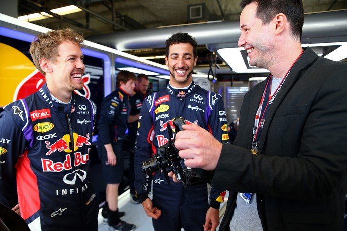 Sebastian Vettel e Daniel Ricciardo mostram um volante de Fórmula 1 para Keanu Reeves (Foto: Getty Images)