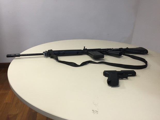 Fuzil e pistola que seriam de Playboy e comparsas foram apreendidos (Foto: Henrique Coelho/G1)