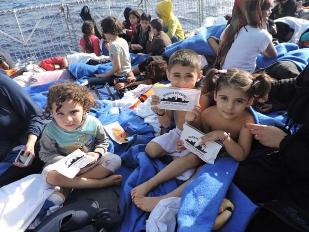Crianças imigrantes são transportadas em embarcação brasileira na costa da Itália (Foto: Marinha do Brasil)