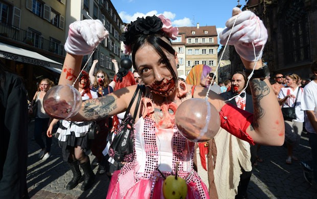 "Morta-viva" segura recipientes com sangue falso durante marcha dos zumbis neste sábado. (Foto: Patrick Hertzog/AFP)